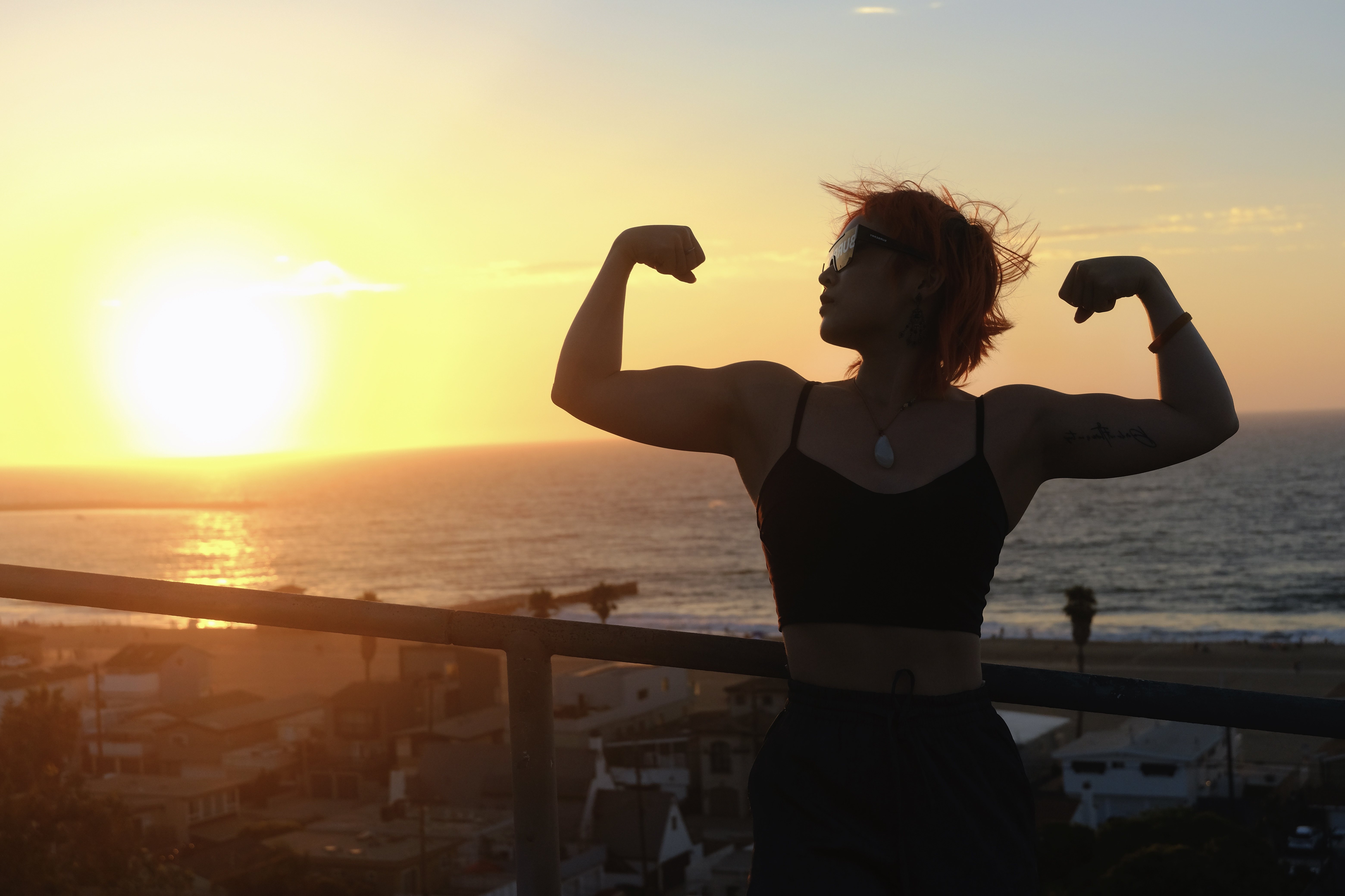 A woman in silhouette showing strength and confidence at sunset, representing the line 'Darling, you look perfect tonight'